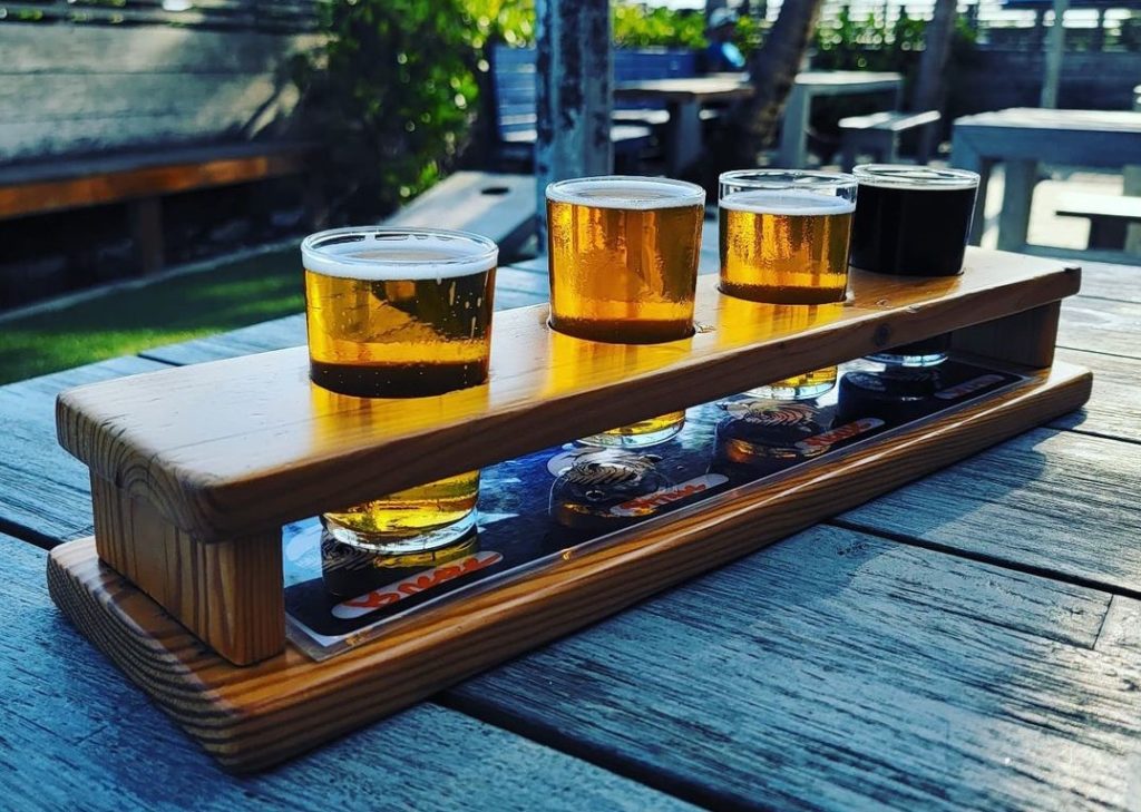 A flight of IPAs, showing the different styles and colors of each.