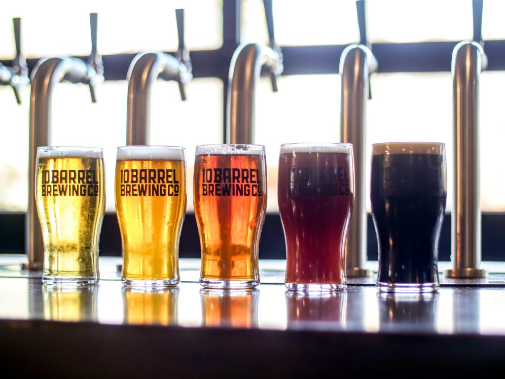 An image of five different craft beers on tap at a craft brewery. 